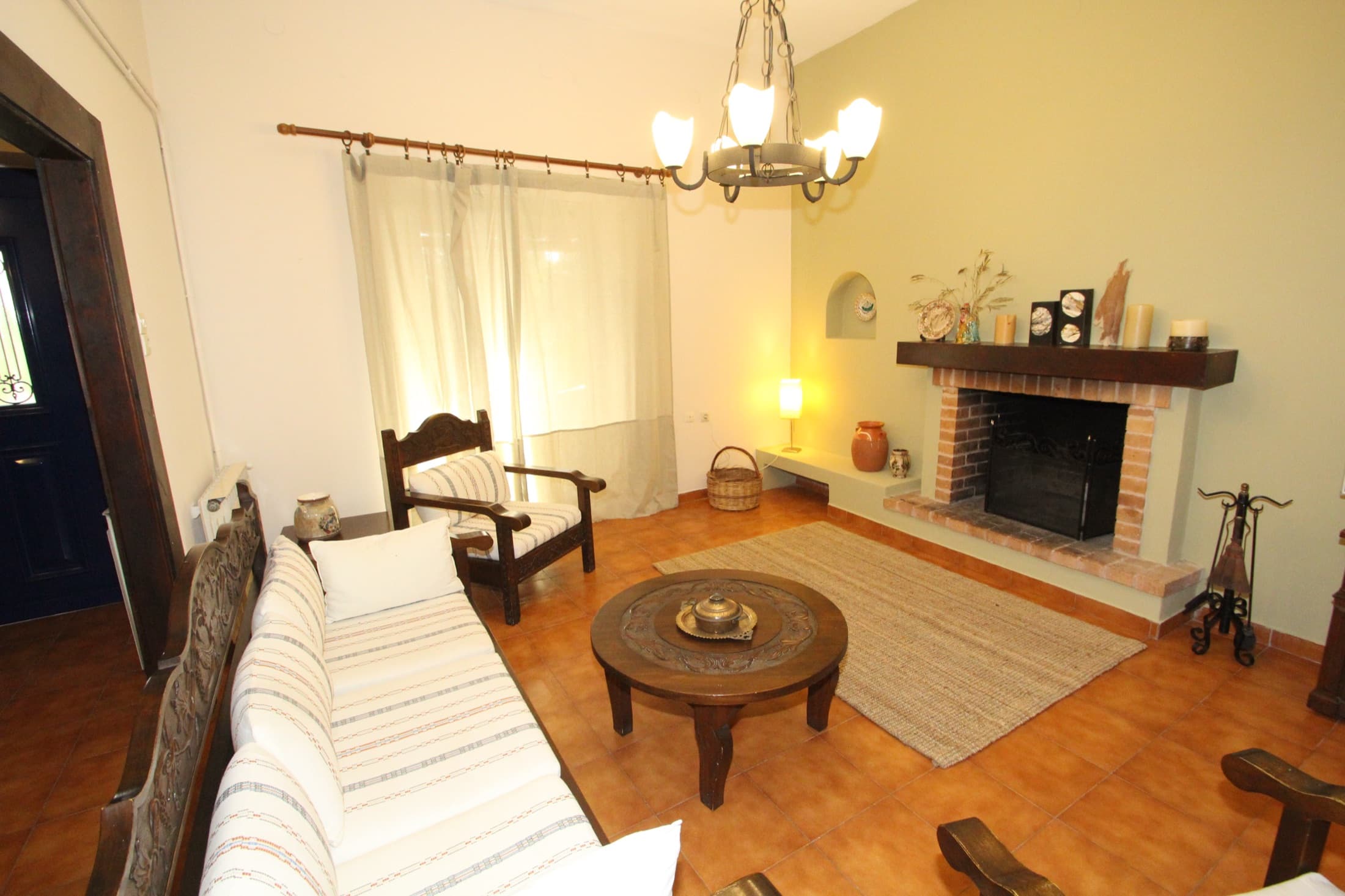 Cosy sitting room with fireplace at Fistiki House